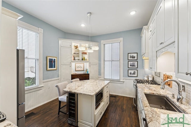 kitchen with hanging light fixtures, sink, dark hardwood / wood-style flooring, and a kitchen island