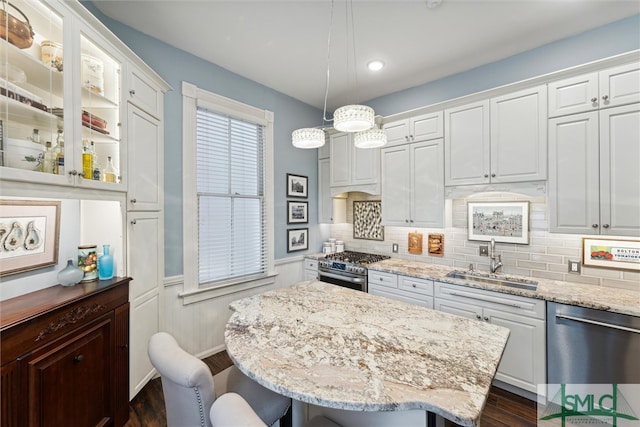 kitchen featuring appliances with stainless steel finishes, a center island, white cabinetry, and sink