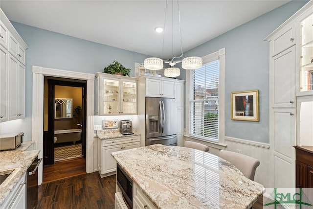 kitchen with dark wood-type flooring, white cabinetry, light stone counters, and stainless steel appliances