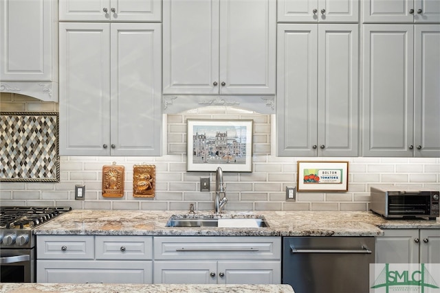 kitchen featuring light stone countertops, stainless steel appliances, sink, decorative backsplash, and custom exhaust hood