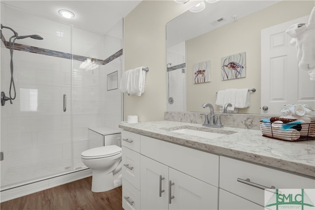 bathroom with vanity, toilet, hardwood / wood-style floors, and a shower with shower door