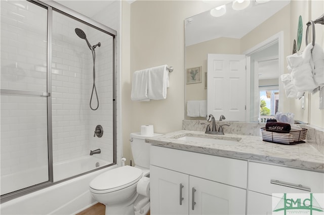 full bathroom featuring shower / bath combination with glass door, toilet, and vanity