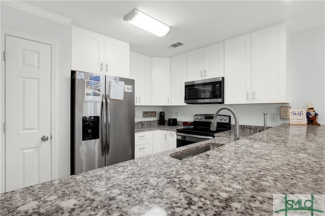 kitchen with white cabinets, appliances with stainless steel finishes, light stone countertops, sink, and ornamental molding