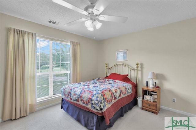 bedroom with light colored carpet, ceiling fan, and multiple windows