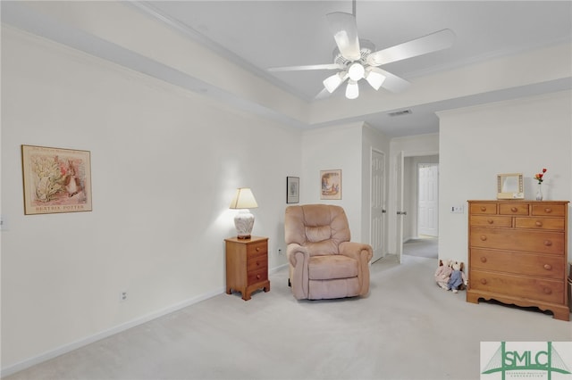 sitting room featuring crown molding, a tray ceiling, ceiling fan, and light colored carpet