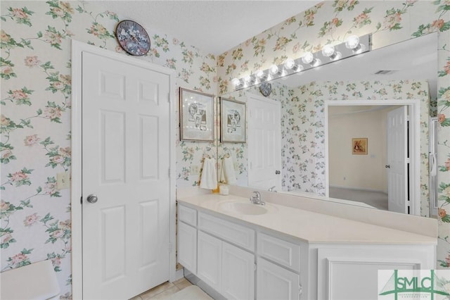 bathroom with tile patterned floors, visible vents, vanity, and wallpapered walls