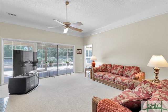 carpeted living area featuring a textured ceiling, a ceiling fan, visible vents, and crown molding