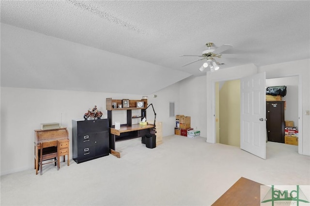 interior space with vaulted ceiling, ceiling fan, a textured ceiling, and carpet flooring