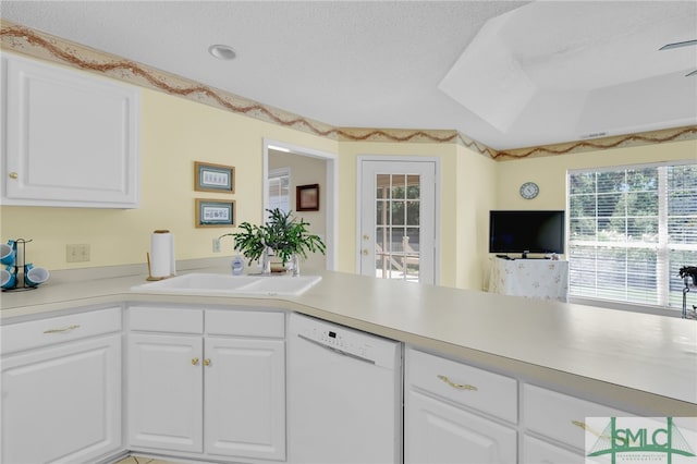 kitchen featuring a tray ceiling, dishwasher, white cabinetry, and a textured ceiling