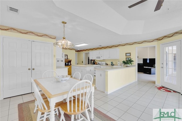 dining room featuring ceiling fan with notable chandelier, visible vents, and light tile patterned flooring