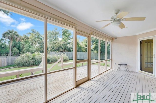 unfurnished sunroom featuring ceiling fan