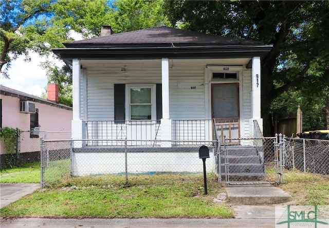 bungalow-style house with a wall mounted air conditioner and a porch