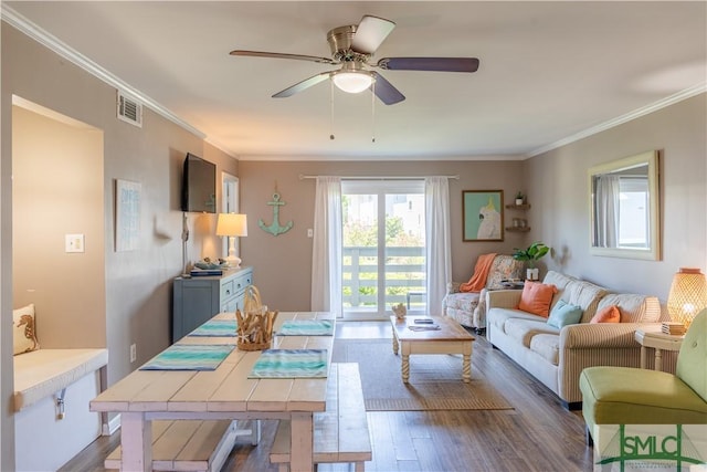 living room with visible vents, crown molding, a ceiling fan, and wood finished floors