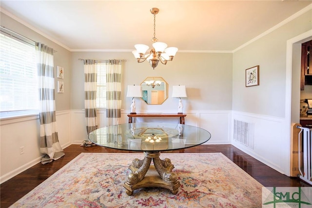 dining room with visible vents, an inviting chandelier, wood finished floors, and wainscoting