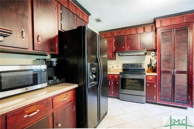 kitchen with visible vents, under cabinet range hood, light countertops, appliances with stainless steel finishes, and light tile patterned flooring