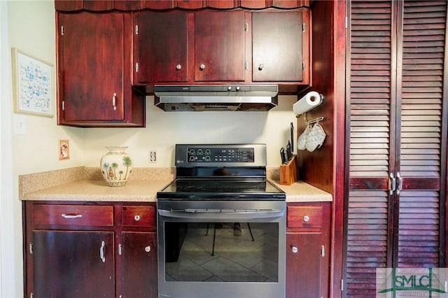 kitchen with stainless steel electric range oven, ventilation hood, dark brown cabinets, and light countertops