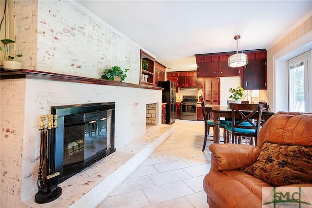 living room with light tile patterned floors, a brick fireplace, and ornamental molding