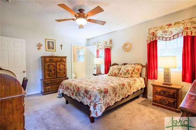 bedroom featuring baseboards, carpet flooring, a textured ceiling, and a ceiling fan