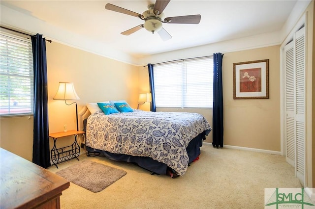 bedroom featuring baseboards, ornamental molding, carpet flooring, a closet, and a ceiling fan