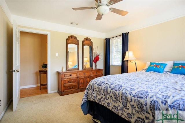 bedroom featuring visible vents, light carpet, baseboards, and ceiling fan