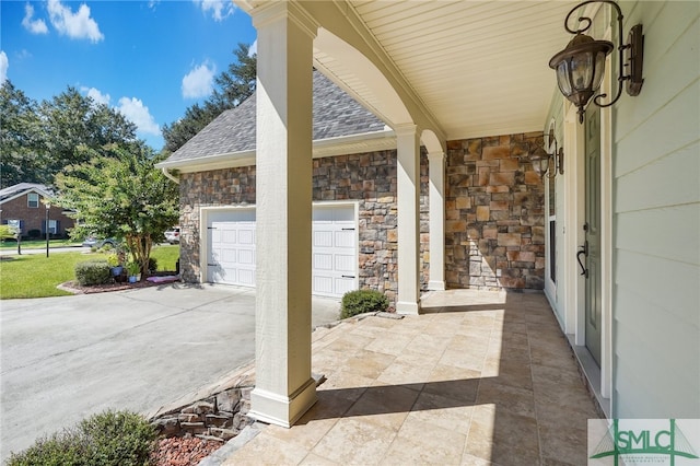 view of patio / terrace with a garage and a porch