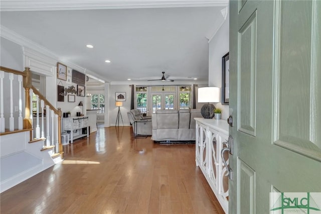 entryway featuring ornamental molding, stairway, wood finished floors, and a ceiling fan