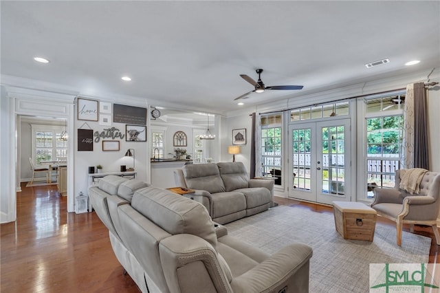 living room featuring ceiling fan with notable chandelier, french doors, plenty of natural light, and light hardwood / wood-style flooring