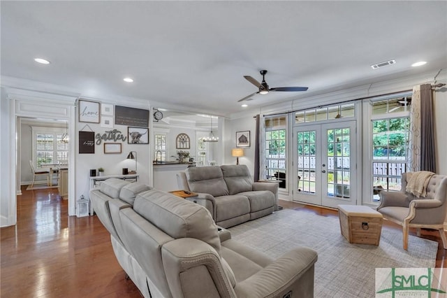 living room featuring visible vents, wood finished floors, ceiling fan with notable chandelier, crown molding, and recessed lighting