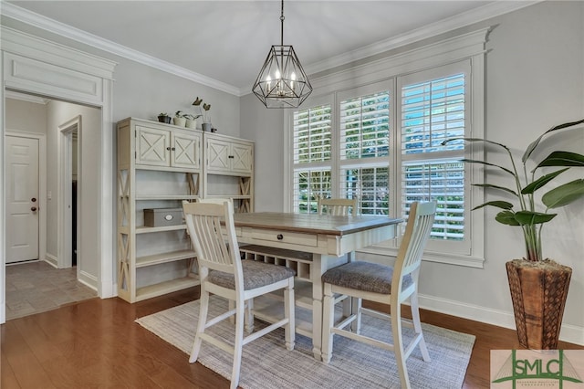 dining space featuring ornamental molding, an inviting chandelier, and dark hardwood / wood-style floors