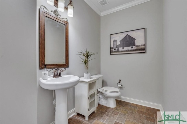 half bathroom featuring toilet, visible vents, baseboards, stone finish floor, and crown molding