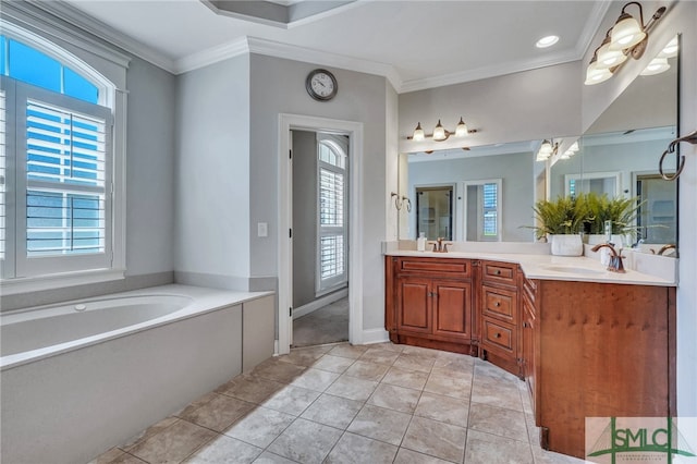 bathroom with crown molding, vanity, a bathing tub, and a wealth of natural light