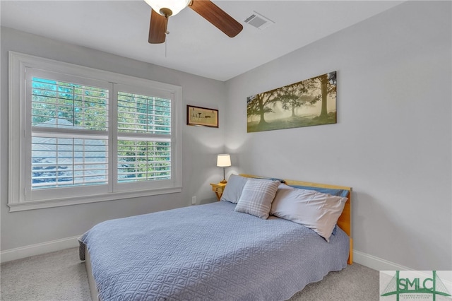 carpeted bedroom featuring ceiling fan and multiple windows