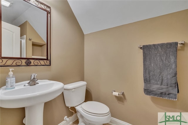 bathroom with lofted ceiling and toilet