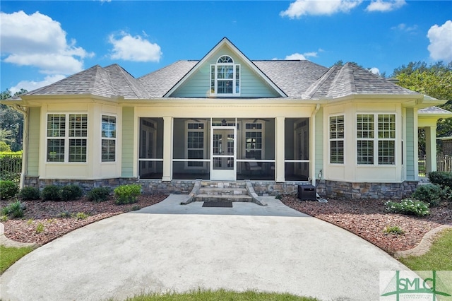 back of property with a sunroom