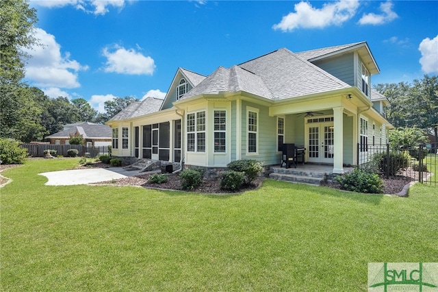 back of property with a yard, ceiling fan, a sunroom, and french doors