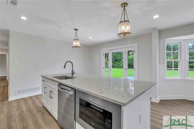 kitchen with light hardwood / wood-style flooring, stainless steel appliances, sink, and a kitchen island with sink