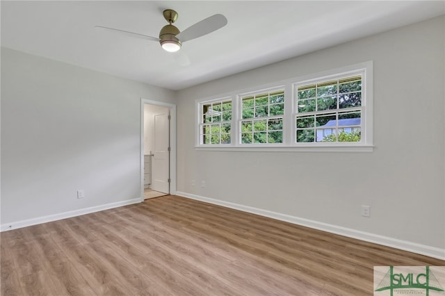 unfurnished room with ceiling fan, a wealth of natural light, and wood-type flooring