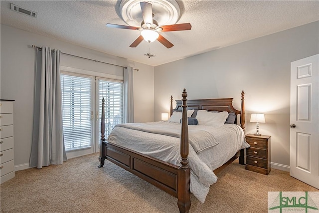 bedroom featuring light carpet, a textured ceiling, visible vents, and access to exterior