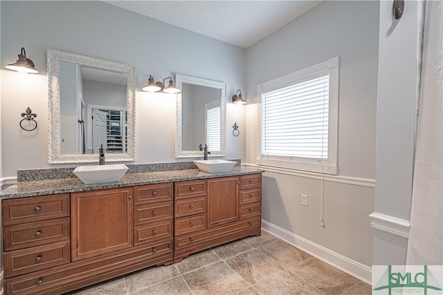 bathroom featuring a textured ceiling, vanity, and tile patterned floors