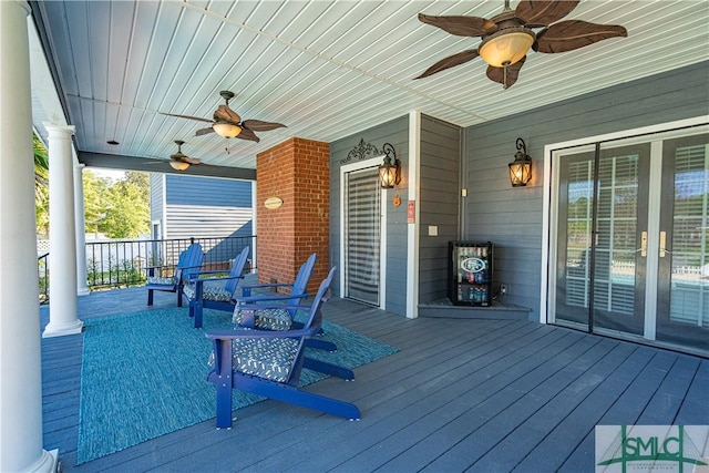 wooden terrace with covered porch and a ceiling fan