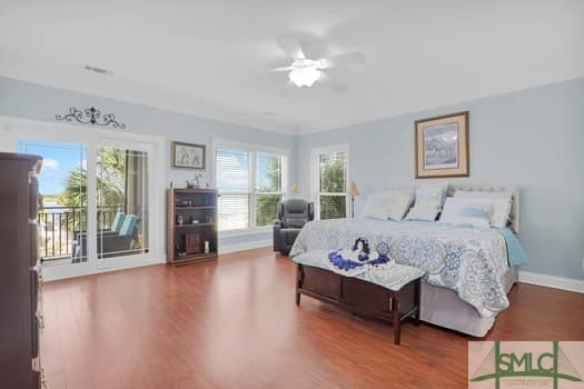 bedroom with multiple windows, baseboards, and wood finished floors