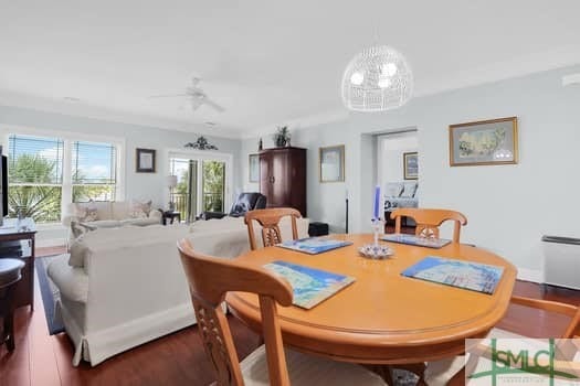 dining room with wood finished floors and ceiling fan with notable chandelier