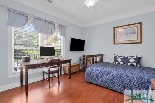 bedroom with visible vents, baseboards, and wood finished floors