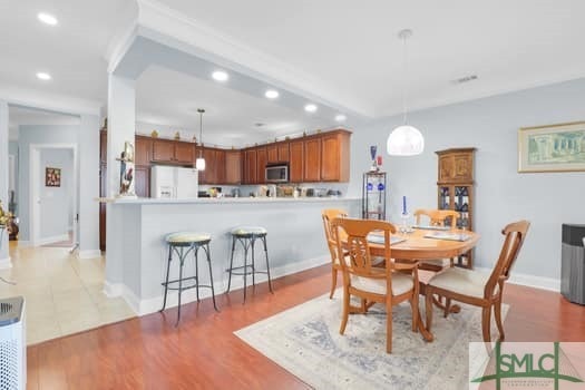 dining room with light wood-type flooring, baseboards, and recessed lighting