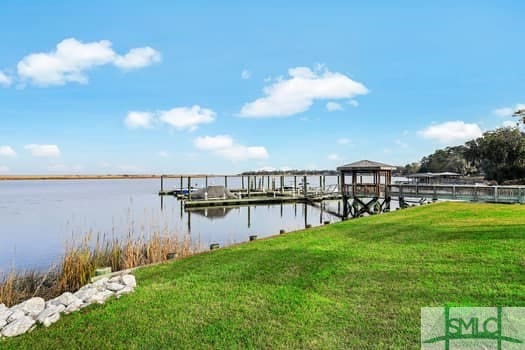 view of dock featuring a yard and a water view