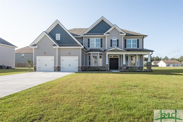 craftsman-style home featuring a porch, a garage, central AC unit, and a front lawn