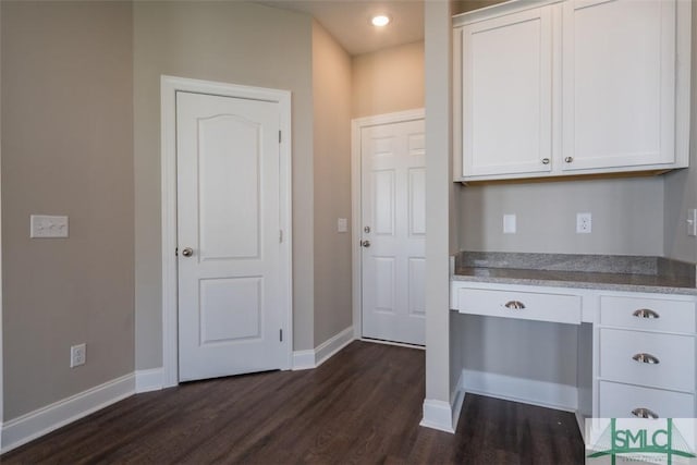 kitchen with dark wood-style floors, baseboards, white cabinetry, and light stone countertops