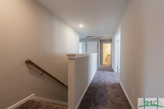 hall featuring carpet floors, an upstairs landing, and baseboards