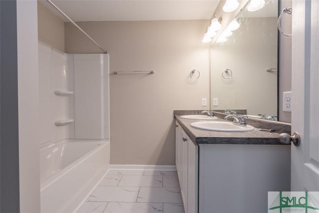 full bathroom with marble finish floor, a sink, baseboards, and double vanity