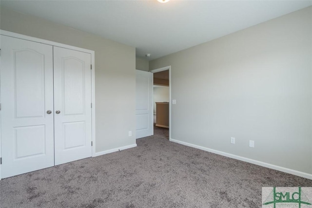 unfurnished bedroom featuring carpet floors, a closet, and baseboards